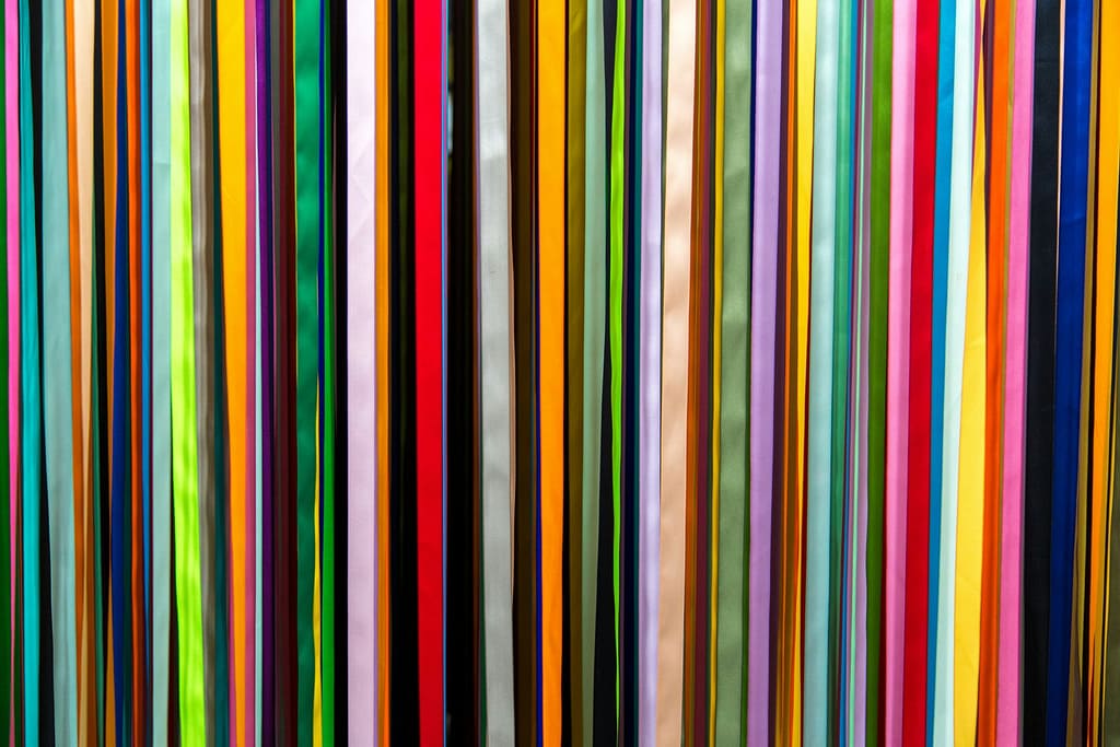 Colorful vertical strips in various hues (complementary, analogous, etc.) illustrate color harmony types, showing how balanced color combos apply to fashion design for visually appealing looks.