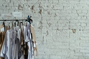 Clothing patterns hanging on a rail against a white brick wall