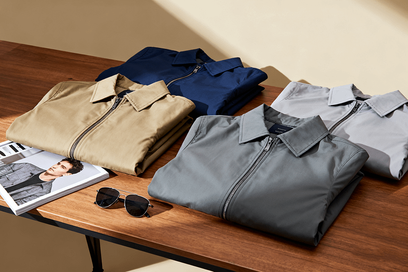 Several men's casual jackets were casually placed on the table.