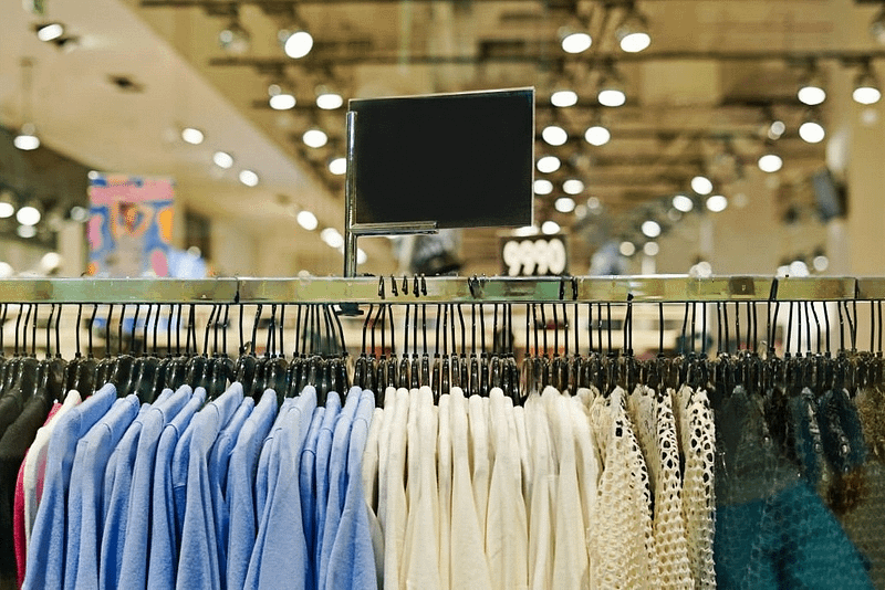 This is a photo taken in a fast fashion store, showing racks full of clothes.