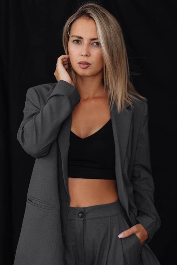 A woman who is going to a formal event wears a blazer over a sports bra, making athleisure more than just casual.