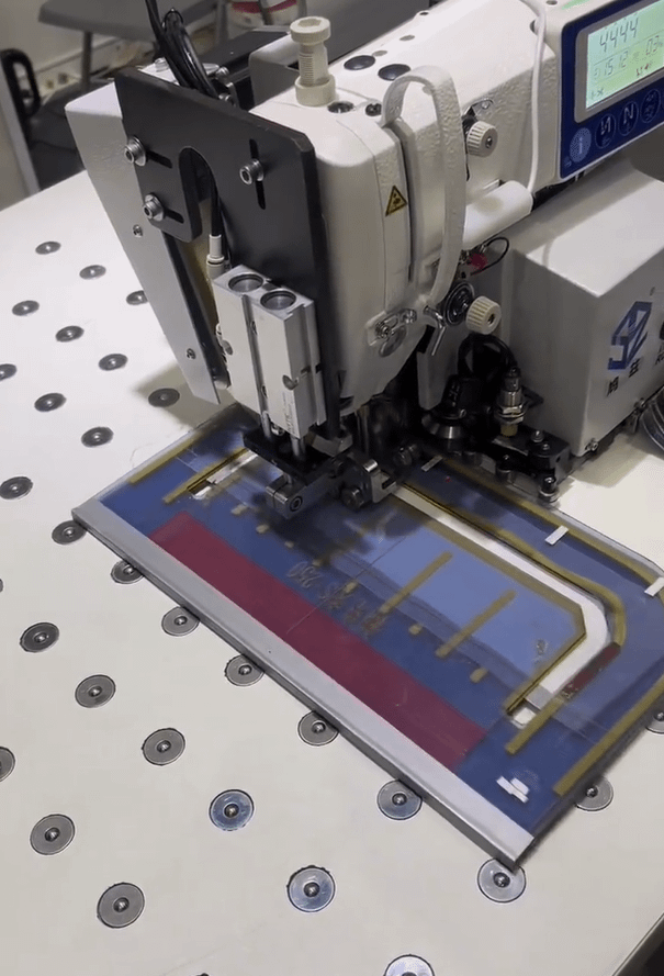 This is a photo showing an automatic sewing machine doing straight line sewing